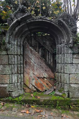Eski, harap olmuş, solgun ahşap kapaklı bir kemerin üstüne granit küller bir duvara kazınmış ve Rue Moal Caddesi 'nin batı yakasındaki bir meyve bahçesine giriş izni verilmiş. Locronan-Brittany-France.