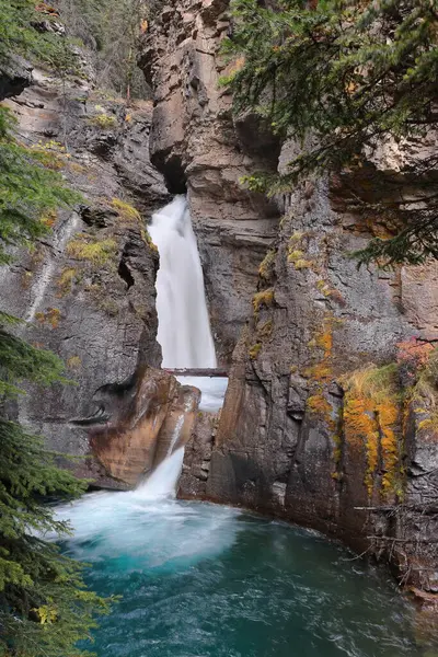Johnston Kanyonu 'nun çağlayan Lower Falls' u eşanlamlı yürüyüş yolu üzerinde, binlerce yıldır manzaralı Johnston Deresi 'nin oyduğu kireçtaşı geçidi boyunca çitli bir yol. Banff-Alberta-Kanada.