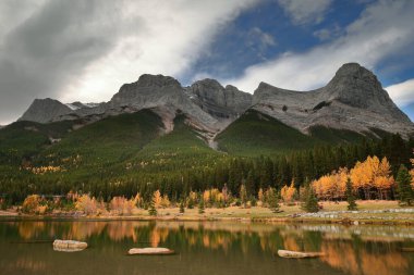 Quarry Gölü 'nün kristal berrak, şeffaf, yeşil suyu Ehagay Nakoda sıradağlarının kaya zirvelerini yansıtır: (L.R.) Gemi Yayı, Lawrence Grassi, Madenci Tepesi, Ha Ling Tepesi. Canmore-Alberta-Kanada.
