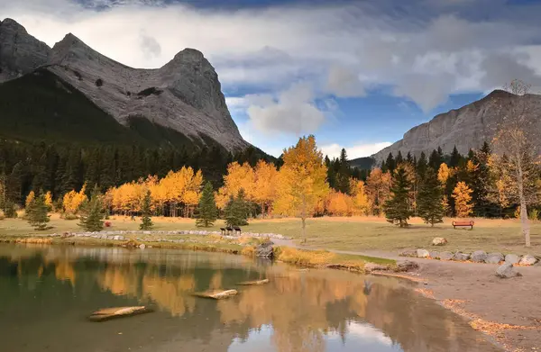 Quarry Gölü 'nün temiz, şeffaf, yeşil suları Ehagay Nakoda Sıradağları' nın (L.R.) en kuzeybatı tepelerini yansıtır: Madenci ve Ha Ling, ve Rundle kütlesinin doğu ucu. Canmore-Alberta-Kanada.