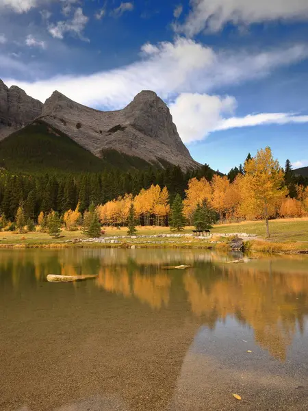 Quarry Gölü 'nün kristal berrak, şeffaf, yeşil suyu Ehagay Nakoda dağ sırasının en kuzeybatı kaya zirvelerini yansıtır: (L.R.) Madenci Tepesi ve Ha Ling Tepesi. Canmore-Alberta-Kanada.