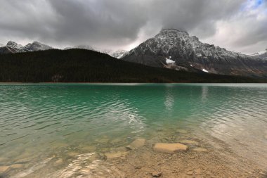 Lower Waterfowl Gölü üzerinden Waputik Sıradağları 'na doğru batıya doğru görüş: 2923 m Midway, 3001 m Aiguille, 2972 m Synge, 3295 m Howse -bulut altında-, 3266 m Chephren ve 3094 m Epaulette. Banff-AB-Kanada.