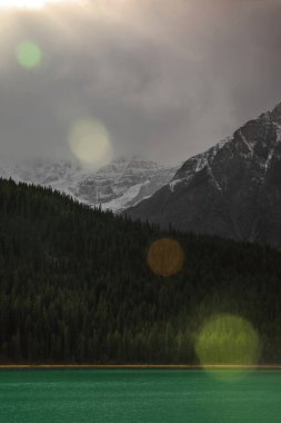 Waputik Sıradağları 'ndan Lower Waterfowl Gölü' ne doğru gelen sanatçı patlaması: 3295 m Howse Tepesi 'nin bulut kaplı zirvesi, 3266 m' lik Chephren. Banff-Alberta-Kanada.