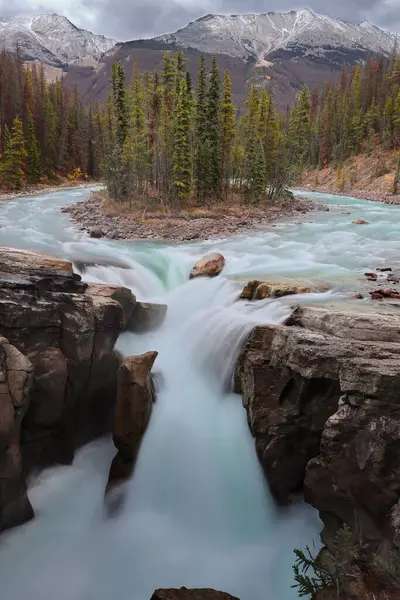 Sunwapta Nehri 'ndeki 18.5 m' lik Sunwapta Şelalesi (türbülans suyu), 2867 m Shackle Peak, 2704 m Sonsuz Zincir Sırtı ve 2730 m Shackle NW2 ile E-NE 'yi destekledi. Jasper NP-Alberta-Kanada.