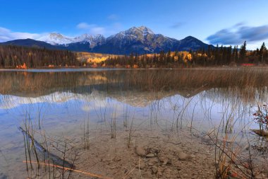 Oldukça açık bir şafağın uzun pozlama görüntüsü: Patricia Lake ile piramit (ortada) ve en soldaki Cairngorm Dağları (en soldaki) gölün kristal berrak sularına yansımaktadır. Jasper NP-Alberta-Kanada.
