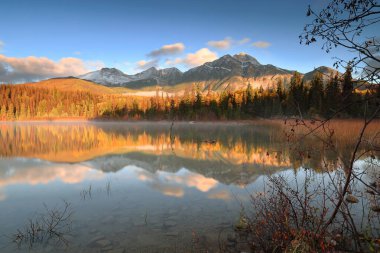 Oldukça açık bir şafağın uzun pozlama görüntüsü: Patricia Lake ile piramit (ortada) ve en soldaki Cairngorm Dağları (en soldaki) gölün kristal berrak sularına yansımaktadır. Jasper NP-Alberta-Kanada.