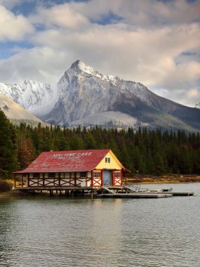 Jasper, Kanada-1 Ekim 2021: 1928, tarihi Maligne Gölü kayıkhanesi, NW gölünün sonunda, Kraliçe Elizabeth Dağları 'ndaki Leah Tepesi eteklerindeki kozalaklı ormanlarla korunuyor..