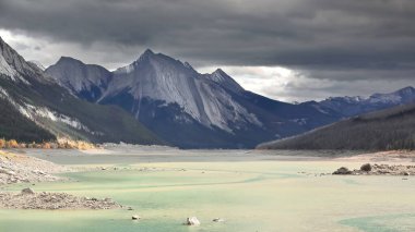 Maligne Nehri 'nin erimiş su mevsimi dışında yer altında aktığı sığ Medicine Gölü havzası Kraliçe Elizabeth Sıraları' nın Annunciation ve Opal kütleleri arka plandadır. Jasper NP-Alberta-Kanada.