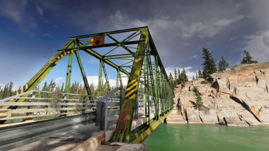 Paslı demir, kiriş boyunca perçinlenmiş Pratt, on panel, yeşil boyanmış, Old Fort Point Yolu 'ndaki Old Fort Point Köprüsü yolu şehrin doğusundaki Athabasca Nehri' ni kapsıyor. Jasper NP-Alberta-Kanada.