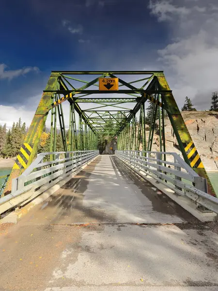 Paslı demir, kiriş boyunca perçinlenmiş Pratt, on panel, yeşil boyanmış, Old Fort Point Yolu 'ndaki Old Fort Point Köprüsü yolu şehrin doğusundaki Athabasca Nehri' ni kapsıyor. Jasper NP-Alberta-Kanada.