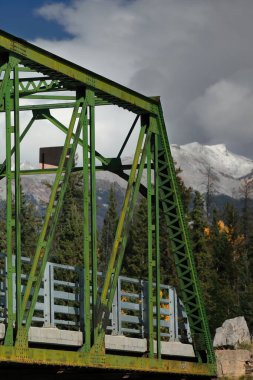 Paslı demir, kiriş boyunca perçinlenmiş Pratt, on panel, yeşil boyanmış, Old Fort Point Yolu 'ndaki Old Fort Point Köprüsü yolu şehrin doğusundaki Athabasca Nehri' ni kapsıyor. Jasper NP-Alberta-Kanada.
