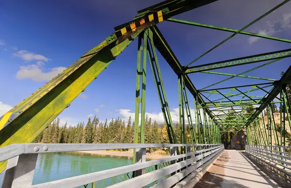 Paslı demir, kiriş boyunca perçinlenmiş Pratt, on panel, yeşil boyanmış, Old Fort Point Yolu 'ndaki Old Fort Point Köprüsü yolu şehrin doğusundaki Athabasca Nehri' ni kapsıyor. Jasper NP-Alberta-Kanada.