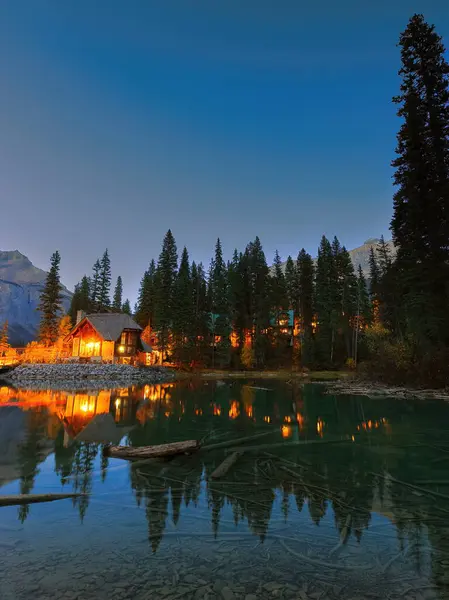Zümrüt Gölü 'nün SW ucundaki Emerald Lodge yarımadasının üzerinde bulutsuz bir alacakaranlık. Arka planda Michael ve Wapta tepeleri var. Field, Yoho NP, British Columbia, Kanada.
