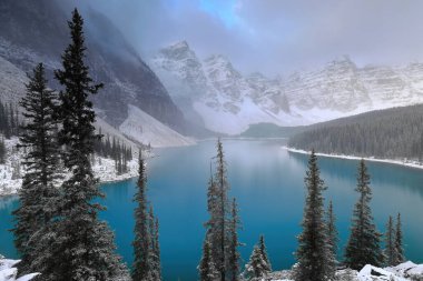 On Tepe Vadisi 'ndeki Turkuaz-Mavi Moraine Gölü yoğun bir kar yağışından hemen sonra Rockpile bakış açısıyla görülen ağaçlar hâlâ karla kaplı. Banff NP-Alberta-Kanada.