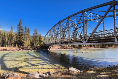 Kale kavşağındaki Bow Dağı eteğindeki Bow nehri boyunca uzanan Banff-Windermere otoyolu üzerinde 1950 yapımı, metal, 9 panelli perçin bağlantılı, sabitlenmiş köprü. Banff NP-Alberta-Kanada.