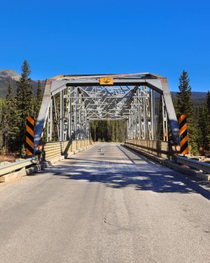 Kale kavşağındaki Bow Dağı eteğindeki Bow nehri boyunca uzanan Banff-Windermere otoyolu üzerinde 1950 yapımı, metal, 9 panelli perçin bağlantılı, sabitlenmiş köprü. Banff NP-Alberta-Kanada.