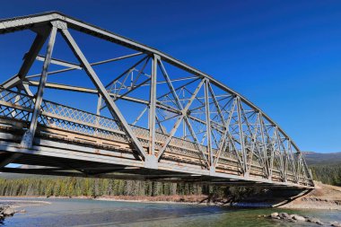 Kale kavşağındaki Bow Dağı eteğindeki Bow nehri boyunca uzanan Banff-Windermere otoyolu üzerinde 1950 yapımı, metal, 9 panelli perçin bağlantılı, sabitlenmiş köprü. Banff NP-Alberta-Kanada.