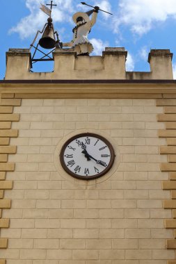 Via di Gracciano nel Corso 'daki XVII c. Pulcinella Kulesi Chiesa di Sant' Agostino Kilisesi 'ne bakıyor. Metal kaplı bir ahşap otomatın tepesinde, çan saatleri başlar. Montepulciano-Toskana-İtalya.
