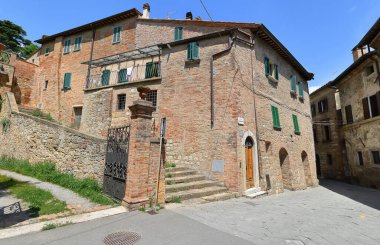 Geç Rönesans tarzında kırmızı tuğla işçiliğinin büyük bir köşesi. 30 Via del Poliziano 'da yeşil boyalı, ahşap hoparlörler ve yuvarlak kemerli kapılar var. Montepulciano-Toskana-İtalya.