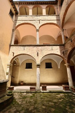 Rönesans tarzı Palazzo Bellarmino Sarayı, XVI yüzyılının güney tarafındaki porticoed avlusunda 10 Via di San Donato Caddesi 'nde gün ortası güneşiyle aydınlatılır. Montepulciano-Toskana-İtalya.