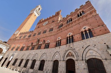 Siena, İtalya-12 Mayıs 2022: Gotik Palazzo Pubblico ya da Comunale Sarayı, 1297-1310 numaralı belediye binası, Torre del Mangia Kulesi tarafından çevrelenmiş üç ceset, Piazza del Campo Meydanı 'nın kuzeybatı cephesi..