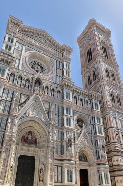 Florence, Italy-May 17, 2022: Side-front view of the Cattedrale di Santa Maria del Fiore Cathedral bell tower and neo-Gothic facade in polychrome marble by Emilio de Fabris, inaugurated in AD 1887.