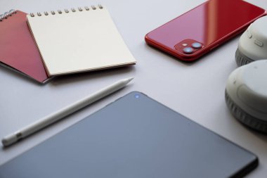 Ofiste çalışma masası. Akıllı telefon, not defteri, kulaklık, tablet ve stil. Modern gerekli elektronik aygıtlar. 