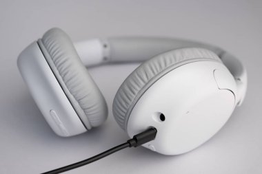 Siyah USB kablosuna bağlı kablosuz gri kulaklıklar yükleniyor