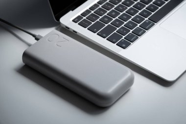 Güçlü bir dış batarya modern ultrabook şarj ediyor. Güç bankası laptopa bağlı. Taşınabilir güç kaynağı. Kesinti pili. 