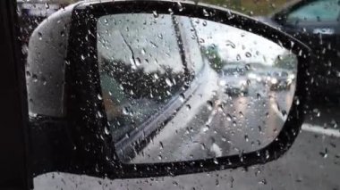 Yağmur sırasında su damlalarındaki arabanın dikiz aynası..