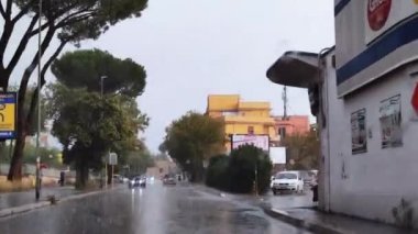Roma İtalya, 10 Ekim. 2022 yılı. Şiddetli yağmur damlalarıyla araba camından geçen yol trafiği. Yağmurda arabanın ön camından görülen trafik manzarası. Yağmurda sürüş.