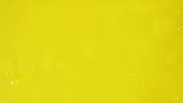 大的透明气泡沿着较小的气泡滑行 在黄色的背景上移动 拍摄广告所需的润肤成分 — 图库视频影像
