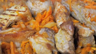 Kızarmış domuz parçalarını havuç şeritli ve soğanlı pişirme işlemi. Gıda hazırlıklarına yakın çekim
