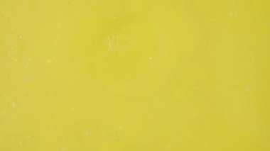 Altın arkaplanda hareket eden yağ kabarcıklarının yavaş çekimi.