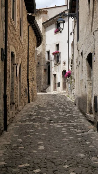 意大利狭窄的街道 有古老的鹅卵石 石头房子和阳台上的花朵 — 图库照片