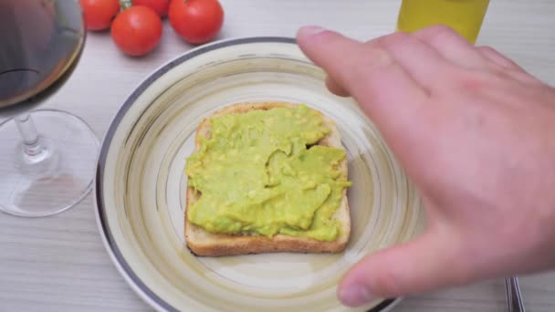 Een Hand Neemt Toast Besmeurd Met Guacamole Van Een Bruine — Stockvideo