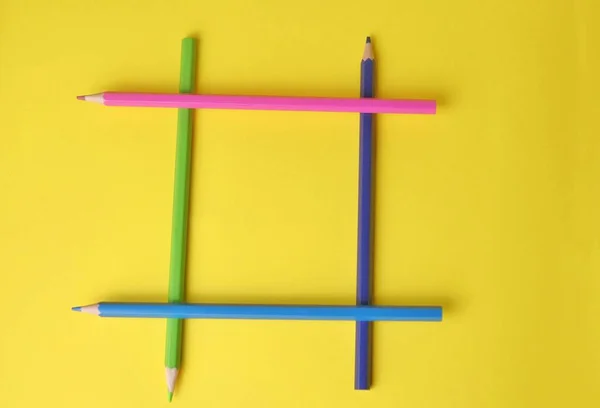 彩色铅笔是以一种黄色背景的指尖游戏的形式摆放出来的 — 图库照片