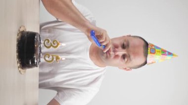 Neşeli adam bir arkadaşının doğum gününü kutluyor. dikey video