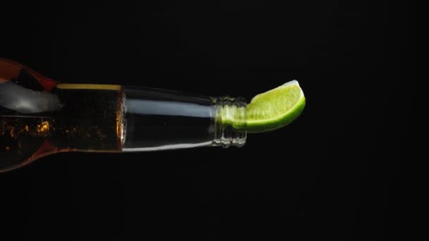 世界中で販売されているビールのほとんどと一緒に黒の背景に石灰とビールのボトル 淡い光の色 メキシコの会社によって生成されます 垂直ビデオ — ストック動画