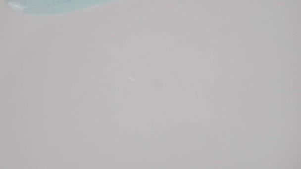 透明的蓝色凝胶液 泡沫在白色表面上流动 宏观射门 — 图库视频影像