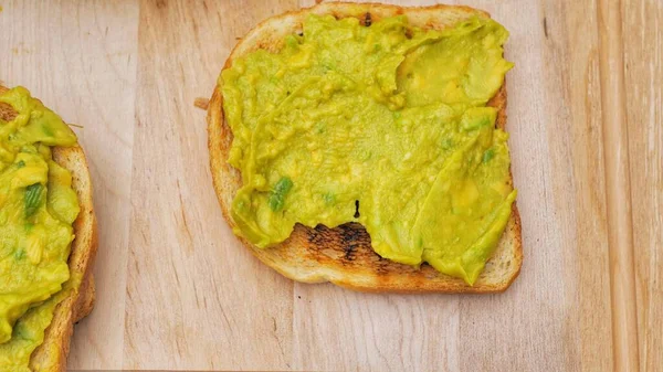 Avocado toast on whole grain sandwich bread. Table top view. Mashed avocado toasts. Concept of healthy eating, dieting, vegan vegetarian food.