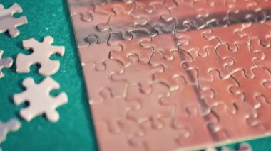 Bulmacayı tamamlıyorum. Bir kadının eline yapbozun bir parçasını yerleştirirken yaklaş. Oyun, konsantrasyon, yalnızlık, meydan okuma, sabır ve bağlantı kavramı