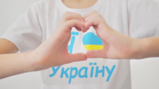 手の心の形でウクライナのフラグを保持します ウクライナ語の碑文私はウクライナが大好きです 戦争を停止するメッセージとウクライナの青と黄色の旗の図面 — ストック動画