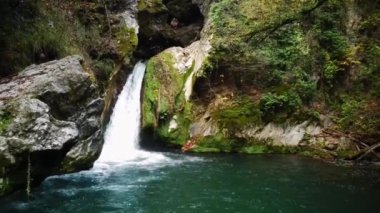 Yeşil yaban ormanı gökyüzü manzaralı güzel bir şelale. Dağ ormanında tropikal. Şelale 4K 'ya yakın. Panoramik güneş manzarası.