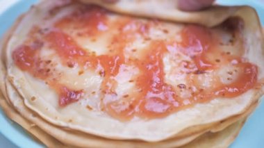 Fransız kreplerine Roseberry reçeli koymak servis tabağına. Evde krep hazırlama kavramı..