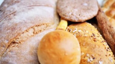 Masanın üzerinde birçok farklı ekmek türü vardır. Yakın çekim, üst görüş. Yiyecek konsepti