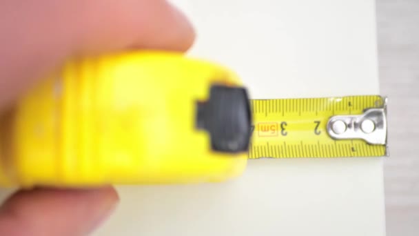 Female Hand Presses Button Orange Metallic Tape Measure Return Spring — Stockvideo