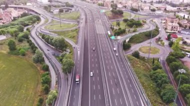 Güneşli bir akşamda çok katlı otoyolda giden arabalara güzel bir üst taraf manzarası. Yol trafiğinin ve günbatımının resimli hava manzarası