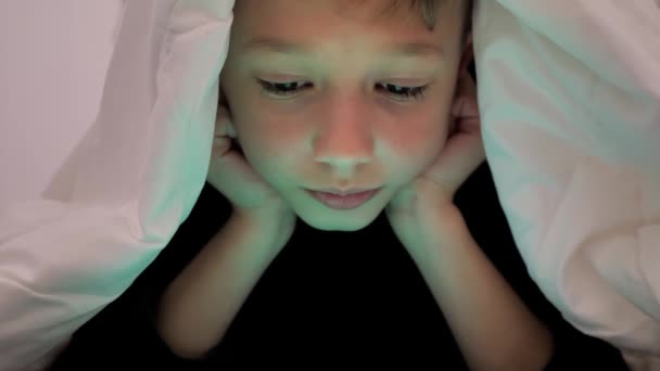 Chlapec Hraje Tabletu Zatímco Leží Pod Dekou Sledování Kreslených Filmů — Stock video
