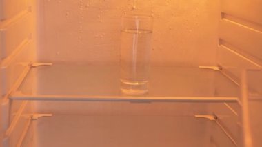 There is only water in the empty refrigerator.